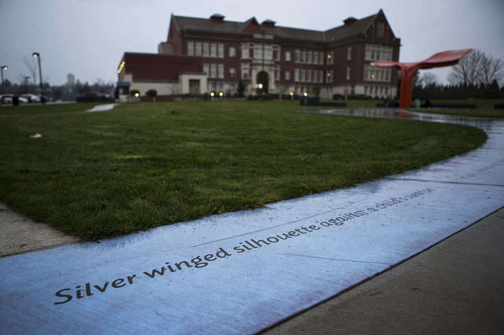 The lyrics of “Angel,” by Jimi Hendrix, are engraved in concrete at Seattle’s Jimi Hendrix Park. In the background is the park’s focal point, a sculpture reminiscent of a butterfly wing. Beyond that is the Northwest African American Museum. (Ian Terry / The Herald)
