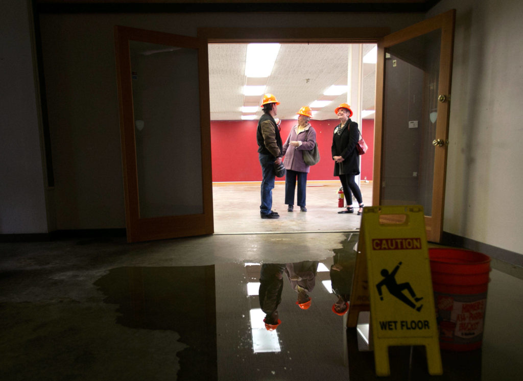 Mike Johnson (from left) Melody Clemans and Terry Lippincott visit the water damaged annex of the Carnegie library building in Snohomish on Wednesday. (Kevin Clark / The Herald)
