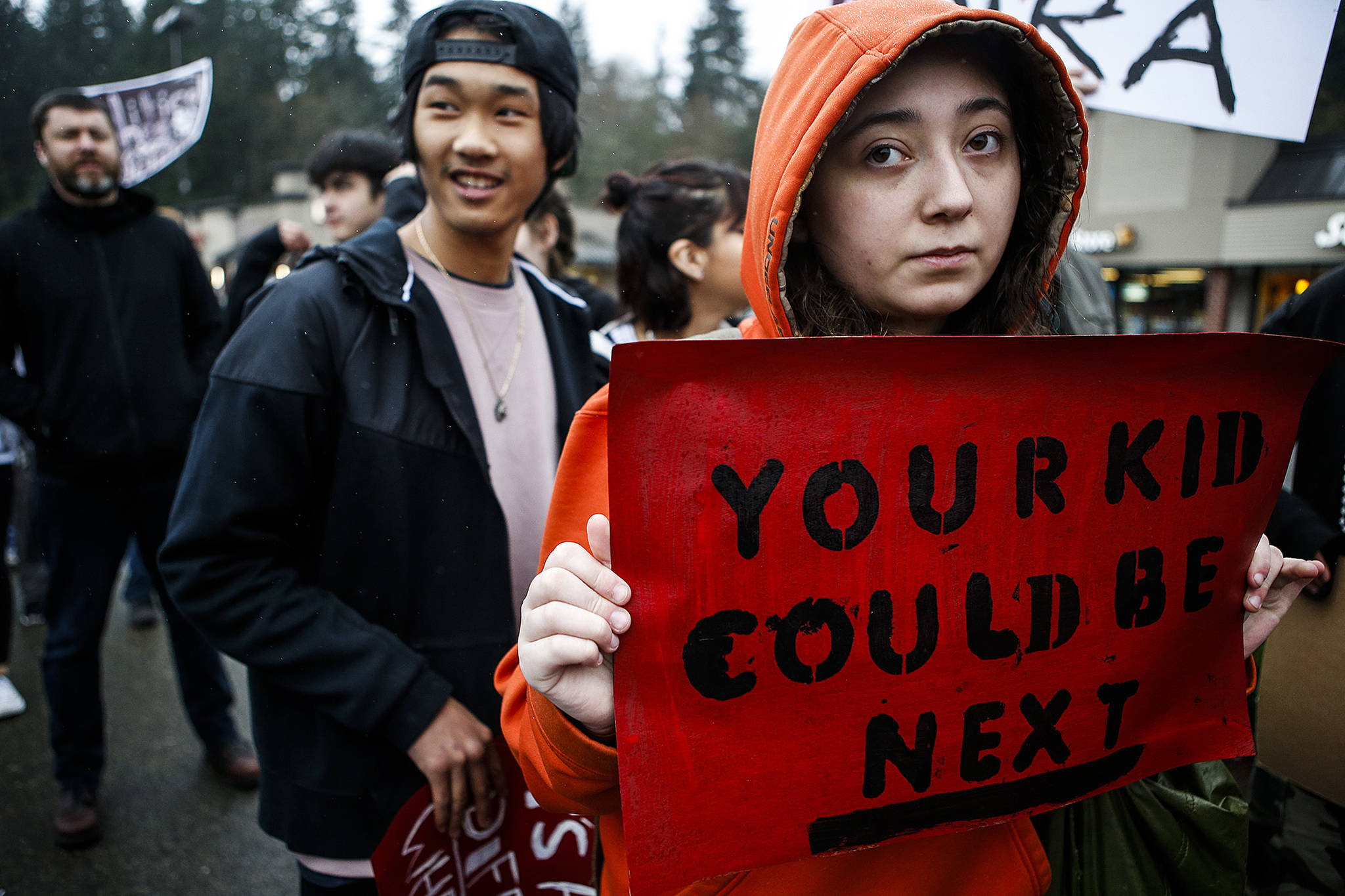 Sydni Hillman (right), a sophomore at Scriber Lake High School in Edmonds, walks out of school Wednesday with other classmates to bring awareness to gun violence. (Ian Terry / The Herald)