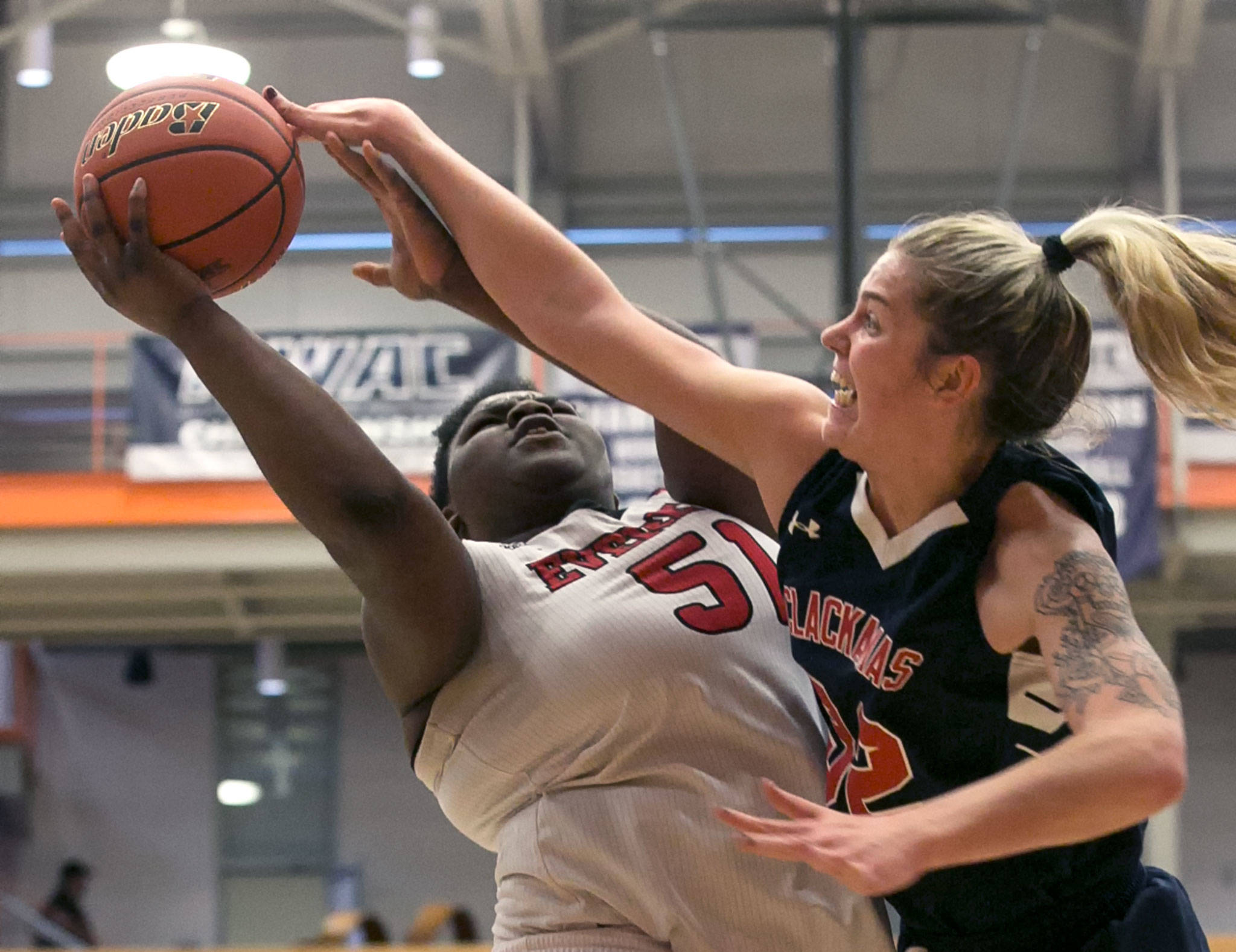 Everett’s Uju Chibuogwu (left) attempts a shot and draws a foul from Clackamas’ Kayce Mock during an NWAC Tournament game on March 8, 2018, at Everett Community College. (Kevin Clark / The Herald)