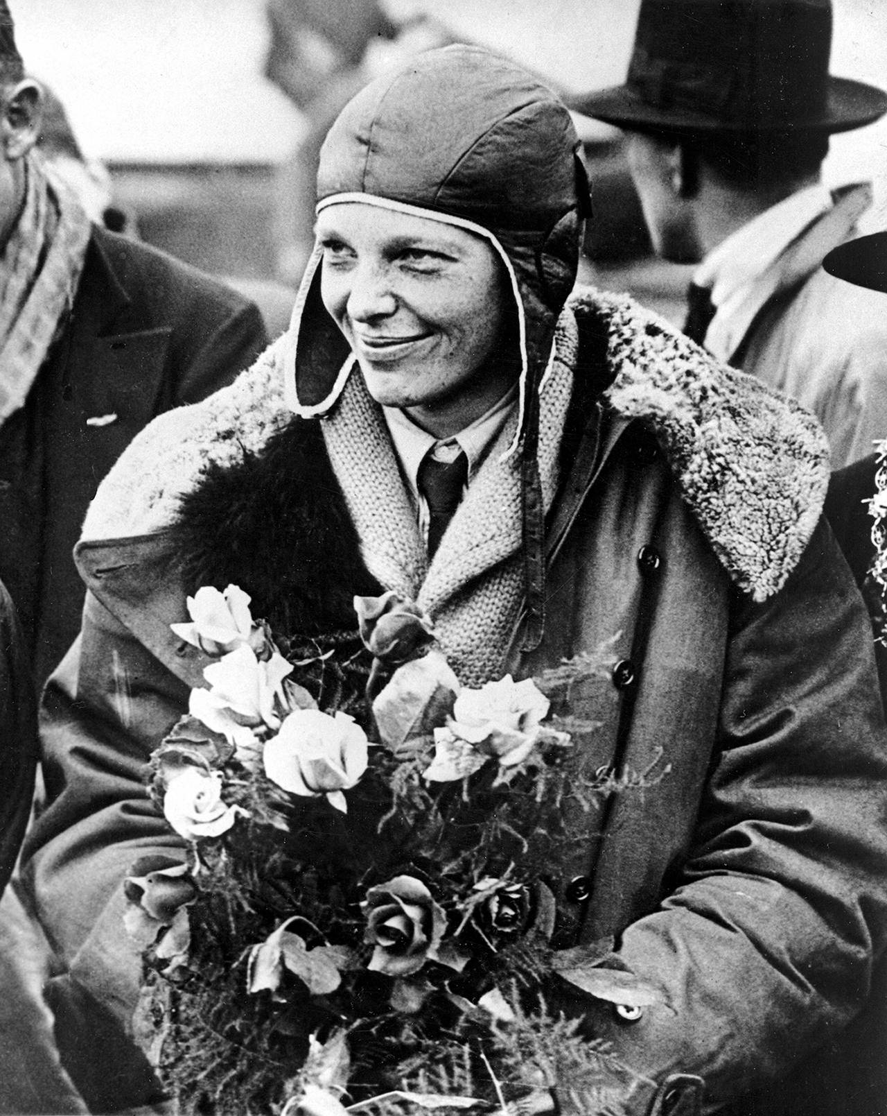 In a June 26, 1928 photo, American aviatrix Amelia Earhart poses with flowers as she arrives in Southampton, England, after her transatlantic flight on the “Friendship” from Burry Point, Wales. (AP Photo, File)