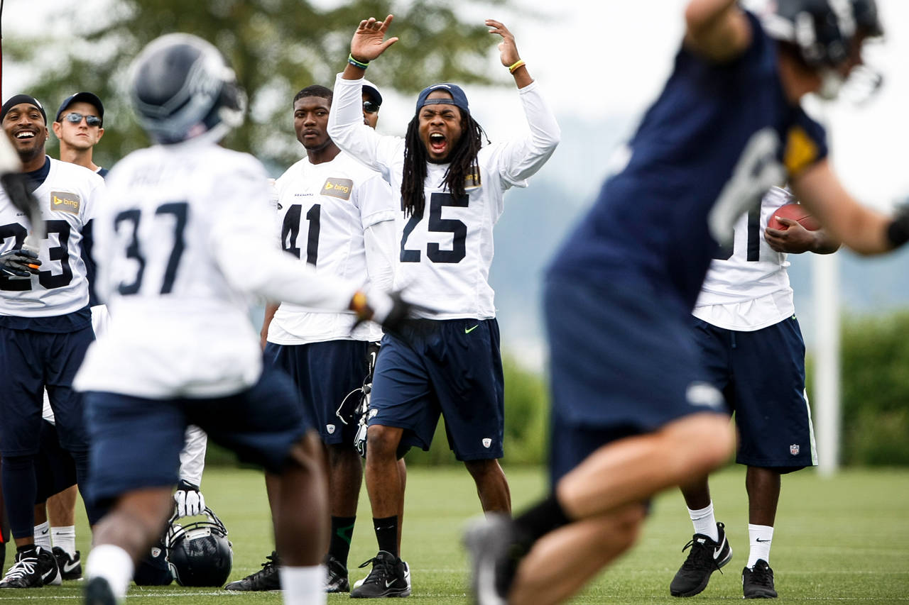 Seattle Seahawks cornerback Richard Sherman (center) reacts to a play on the sidelines during a team practice on Thursday, June 12, 2014 at the Virginia Mason Athletic Center in Renton. (Ian Terry / The Herald)