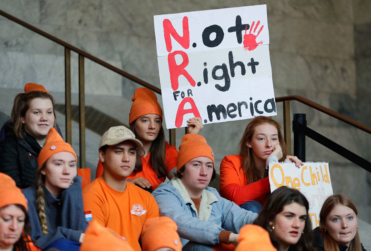 Lydia Ringer, 16, a junior at Roosevelt High School in Seattle, holds a sign that reads “NRA — Not Right for America,” March 6, as she attends a rally against gun violence at the Capitol in Olympia. The rally was held on the same day Gov. Inslee was scheduled to sign a bill banning the sale and possession of gun bump-stocks in the state of Washington. (Ted S. Warren/Associated Press)