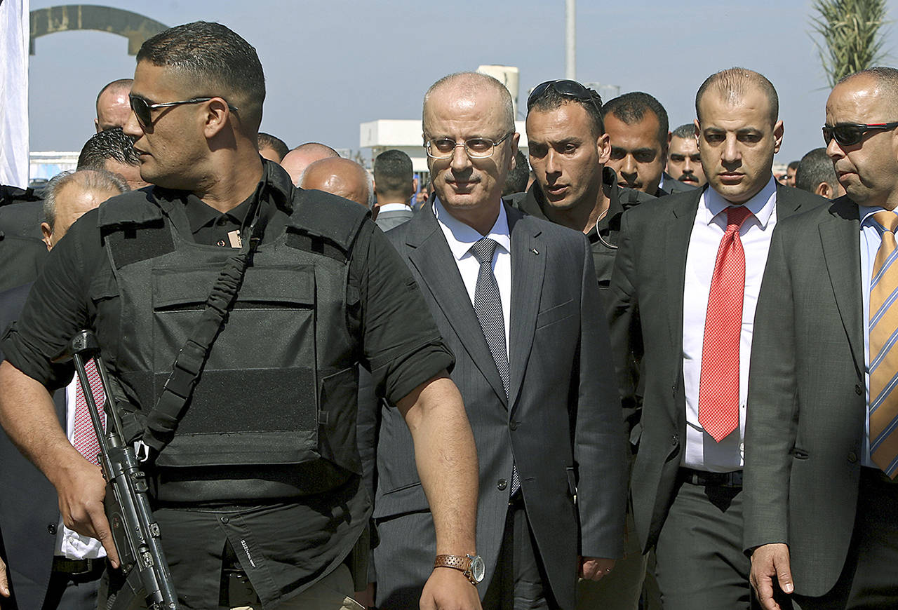 Palestinian Prime Minister Rami Hamdallah (center left) is surrounded by bodyguards as he arrives for the opening ceremony of a long-awaited sewage plant project, east of Jebaliya, in the northern Gaza strip on Tuesday. (AP Photo/Adel Hana)