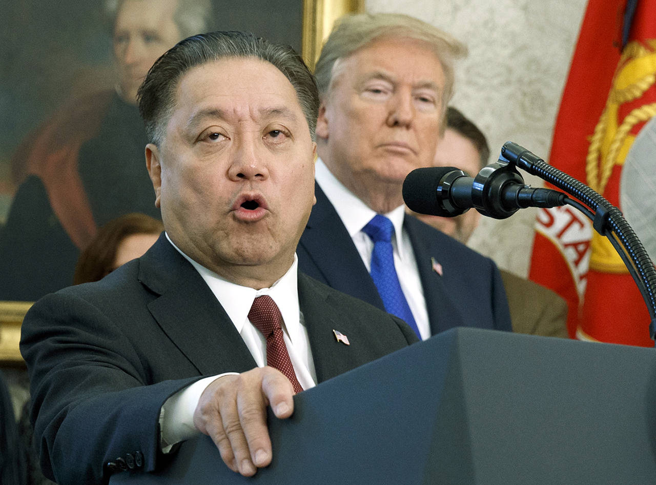 Broadcom CEO Hock Tan speaks while U.S. President Donald Trump listens during an event at the White House in Washington, on Nov. 2, 2017, to announce the company is moving its global headquarters to the United States. (AP Photo/Evan Vucci, File)