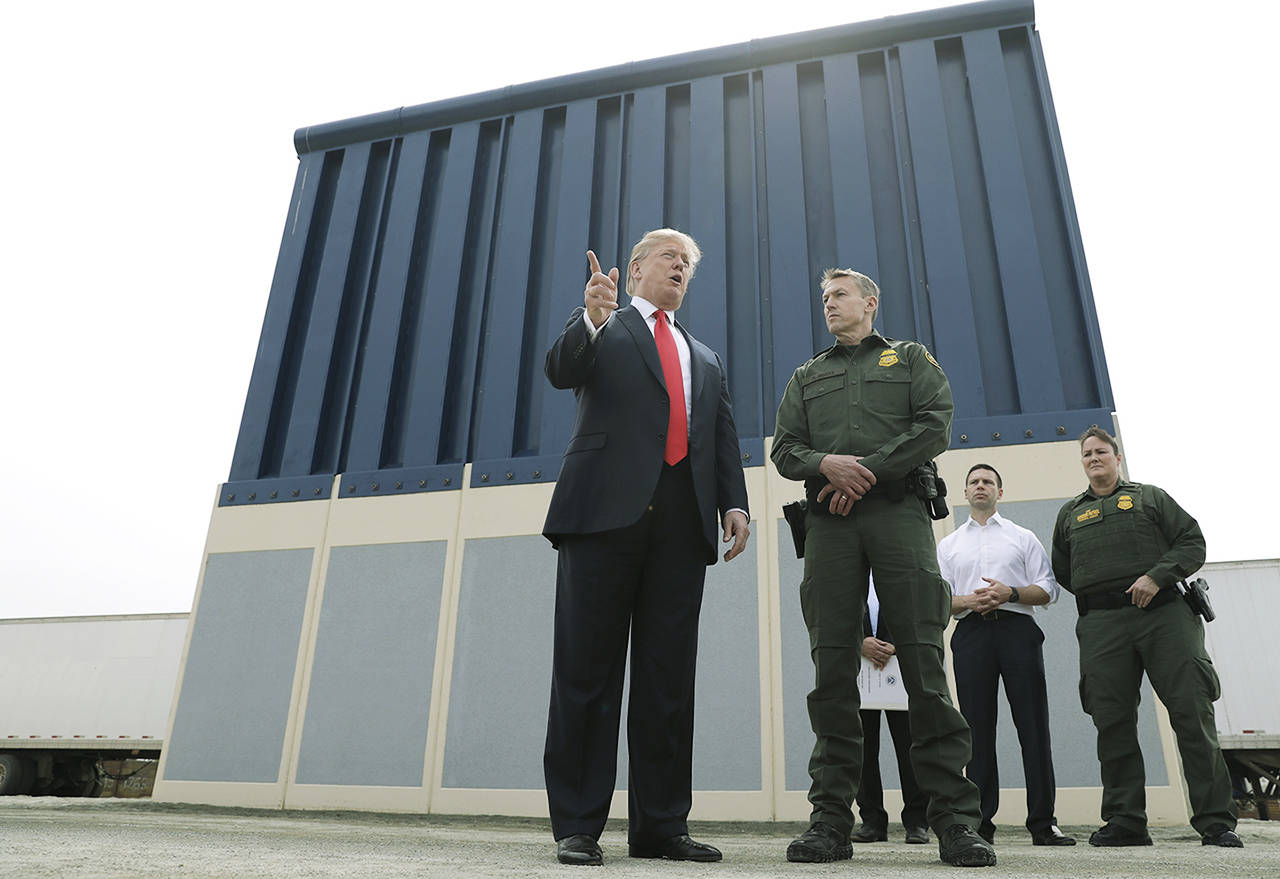 President Donald Trump speaks during a tours as he reviews border wall prototypes Tuesday in San Diego, as Rodney Scott, the Border Patrol’s San Diego sector chief, listens. (AP Photo/Evan Vucci)