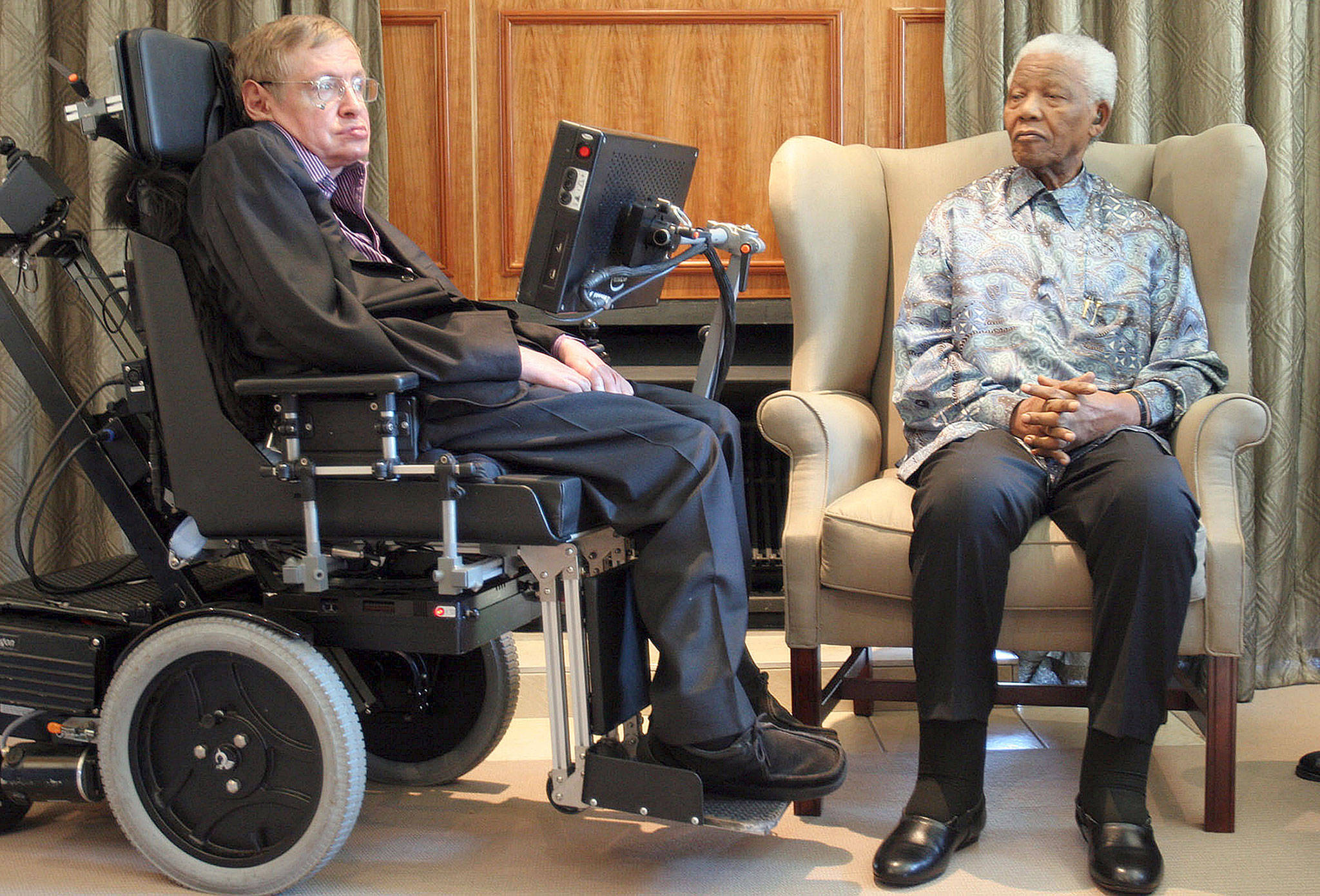 British scientist Stephen Hawking (left) meets with former South African President Nelson Mandela in Johannesburg in 2008. Hawking, whose brilliant mind ranged across time and space though his body was paralyzed by disease, has died. (AP Photo/Denis Farrell, File)