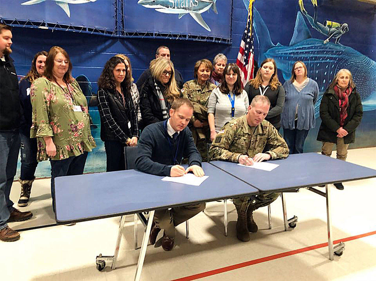 Army Reserve Brig. Gregory Mosser, Commanding General of the 364th Sustainment Command (Expeditionary) based in Marysville, and Cory Taylor, Shoultes Elementary School principal, participate in a signing ceremony Feb. 22, 2018, that officially kicked off their partnership in education. (Contributed photo)