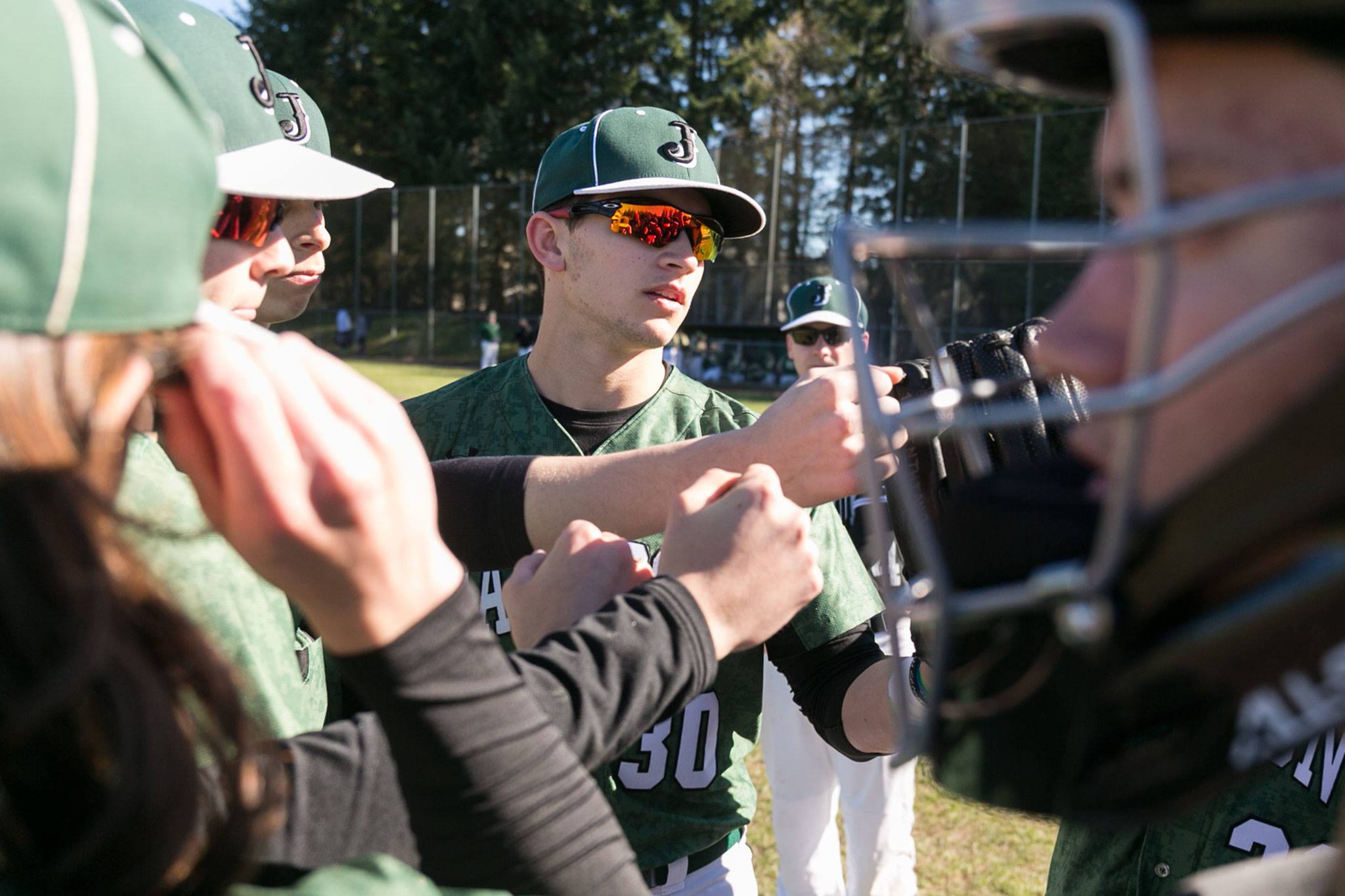 Jackson senior outfielder Carter Booth (center) rallies the team before a game against Marysville Getchell on March 15, 2018, in Mill Creek. (Kevin Clark / The Herald)