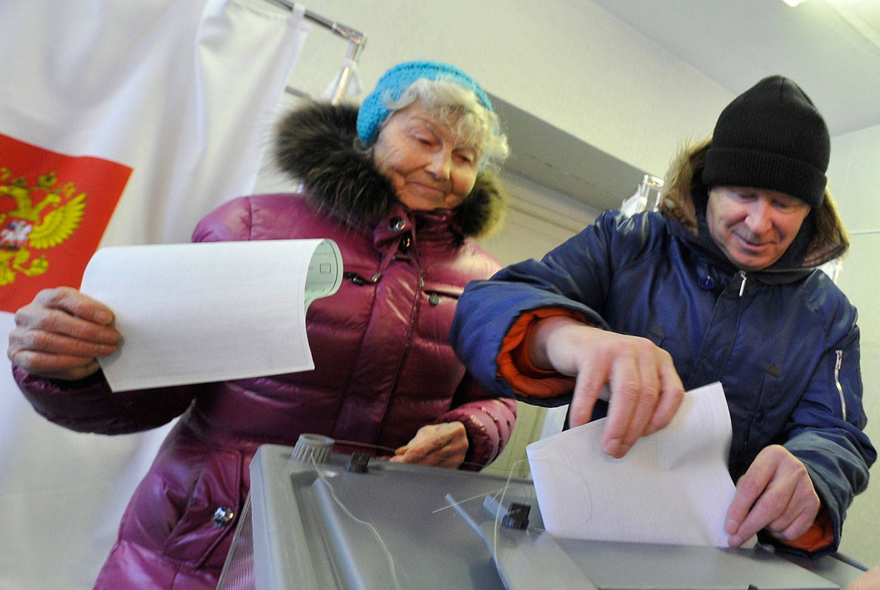 People cast their ballots at a polling station in Yelizovo, about 30 kilometers ( 19 miles) north-east from Petropavlovsk-Kamchatsky, capital of Kamchatka Peninsula region, Russian Far East, Russia, on Sunday, March. 18, 2018. Polls have opened in Russia’s Far East for the presidential election in which Vladimir Putin seeks a 4th term. (AP Photo/Alexander Petpov)