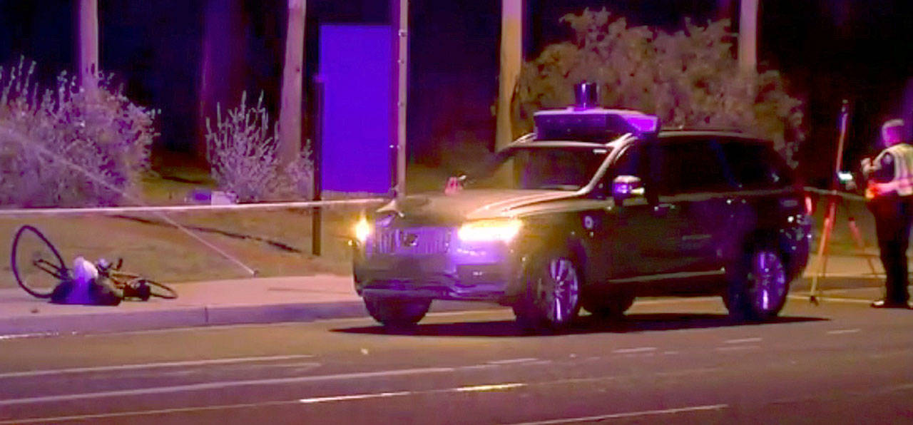 Investigators at the scene of a fatal accident involving a self-driving Uber car on the street in Tempe, Arizona. (ABC-15.com via AP)