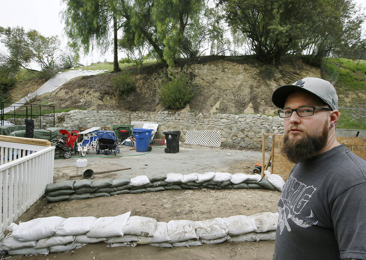 Andrew Joos-Visconti protects his home from the upcoming rains with sand bags in the Sun Valley area of Los Angeles on Tuesday. (AP Photo/Damian Dovarganes)