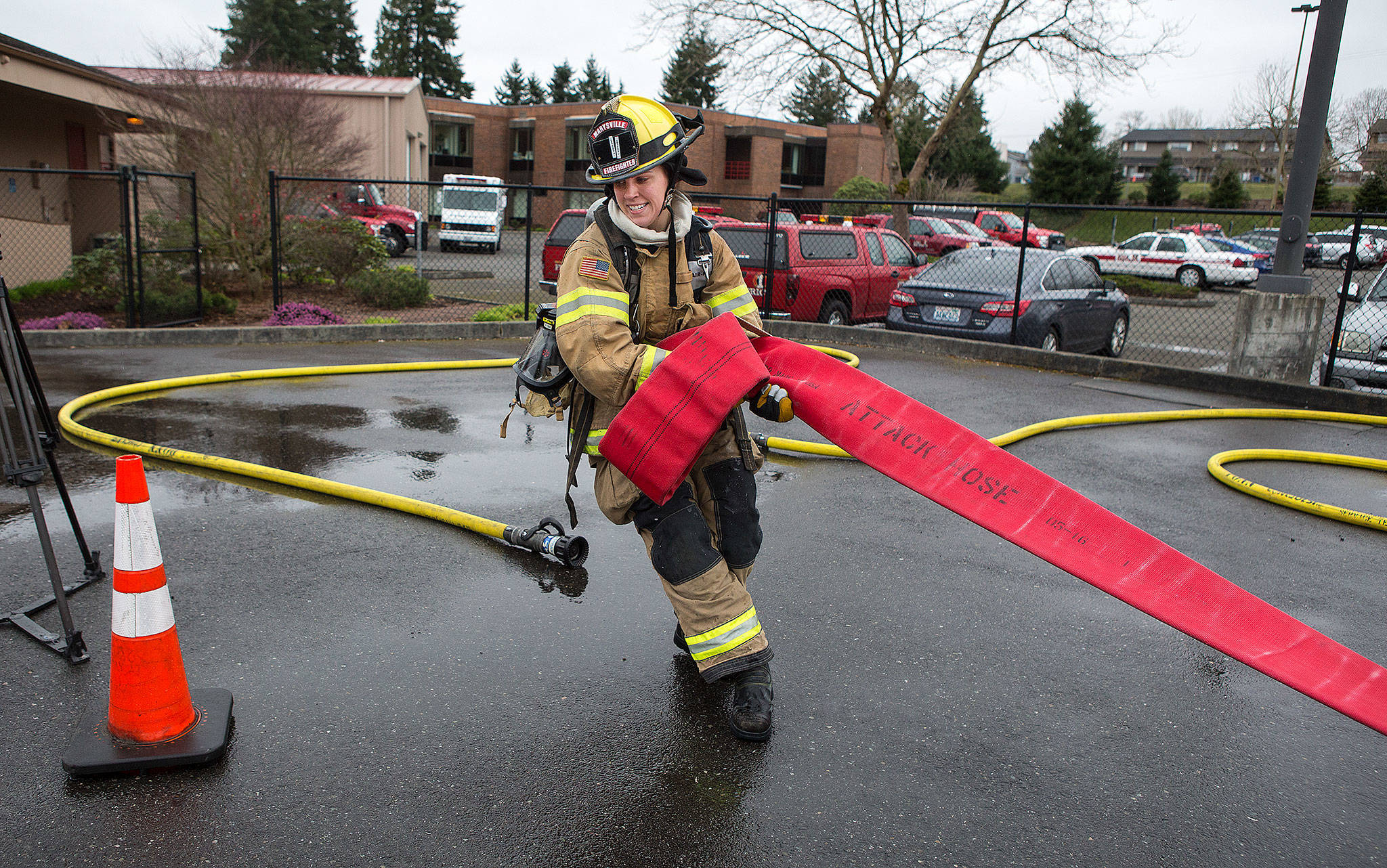 Marysville Fire Department recruit Katie Hereth eyes a cone, marking the finish line, as she hauls a 5-inch, 140-pound line 200 feet in Snohomish County’s first fire training academy obstacle course at the SouthCounty Snohomish Fire & Rescue training grounds Monday in Everett. (Andy Bronson / The Herald)