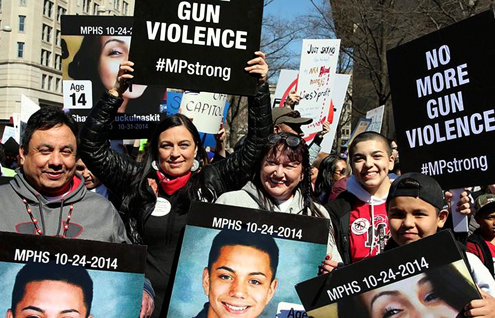 A group of about 20 people from the Tulalip Tribes, including three mothers of victims of the 2014 Marysville High School shooting, marched Saturday in Washington, D.C., to protest gun violence. Deborah Parker, a former vice chairwoman of the tribal board of directors, is holding up a sign. (Deborah Parker photo)