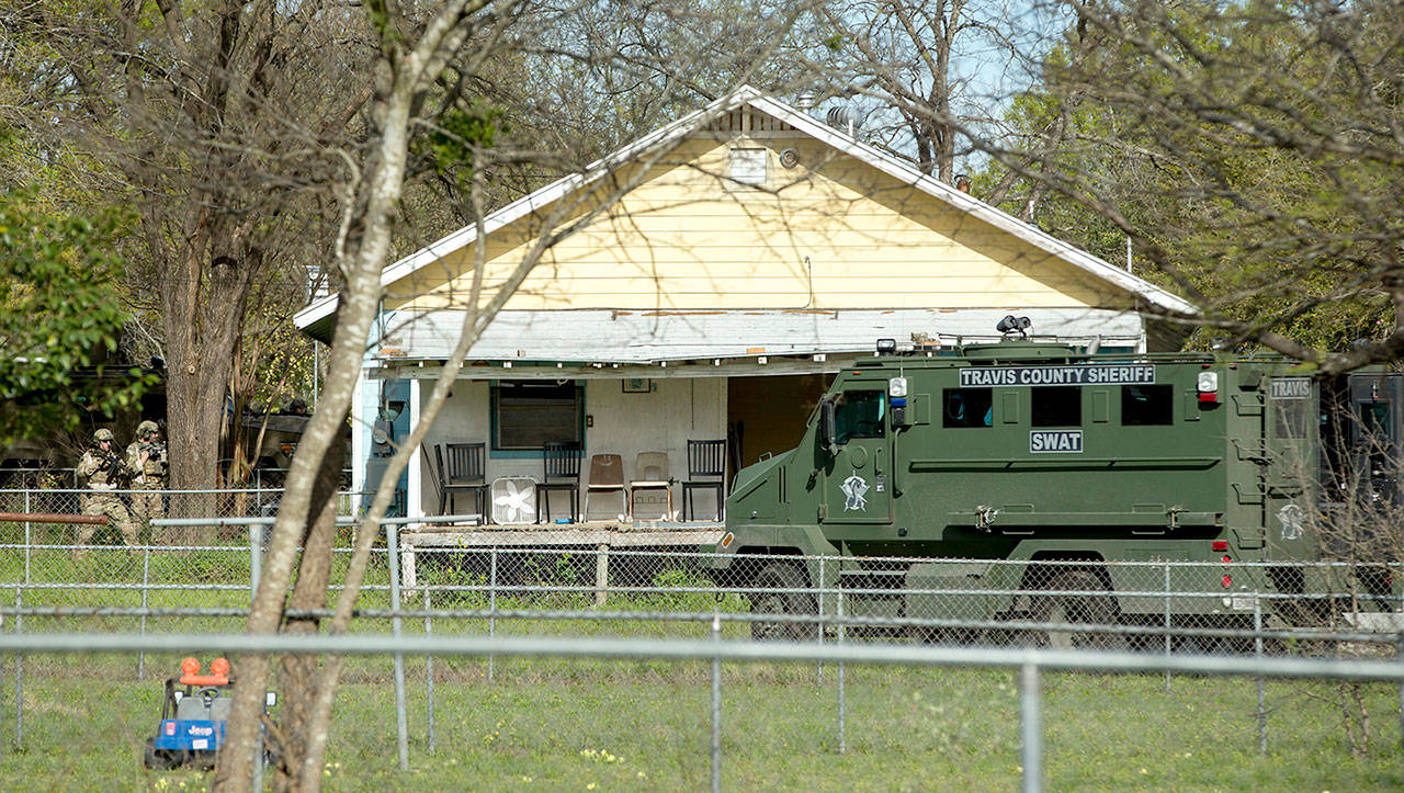 Authorities surround the home of the Austin bombing suspect Mark Conditt in Pflugerville, Texas, on Wednesday. Authorities say Conditt, a man suspected of planting several deadly bombs in the Texas capital this month, blew himself up in a motel parking lot overnight as a SWAT team approached his SUV. (Jay Janner /Austin American-Statesman via AP)