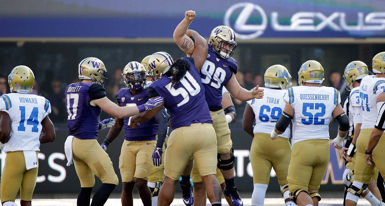 Washington’s Greg Gaines (99) is congratulated after sacking UCLA’s quarterback in the first half of an Oct. 28, 2017 game in Seattle. (AP Photo/Elaine Thompson)