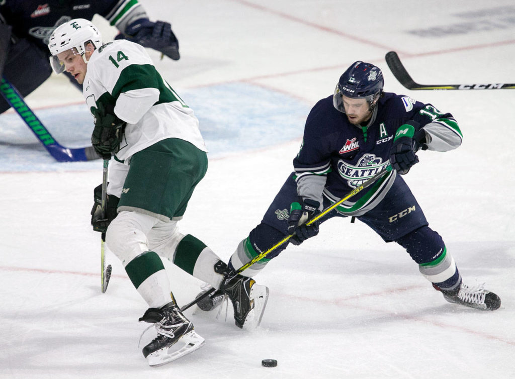 Seattle’s Blake Bargar dislodges the puck form Everett’s Riley Sutter in the second period of a playoff game on March 24, 2018, at Angel of the Winds Arena in Everett. (Kevin Clark / The Herald)
