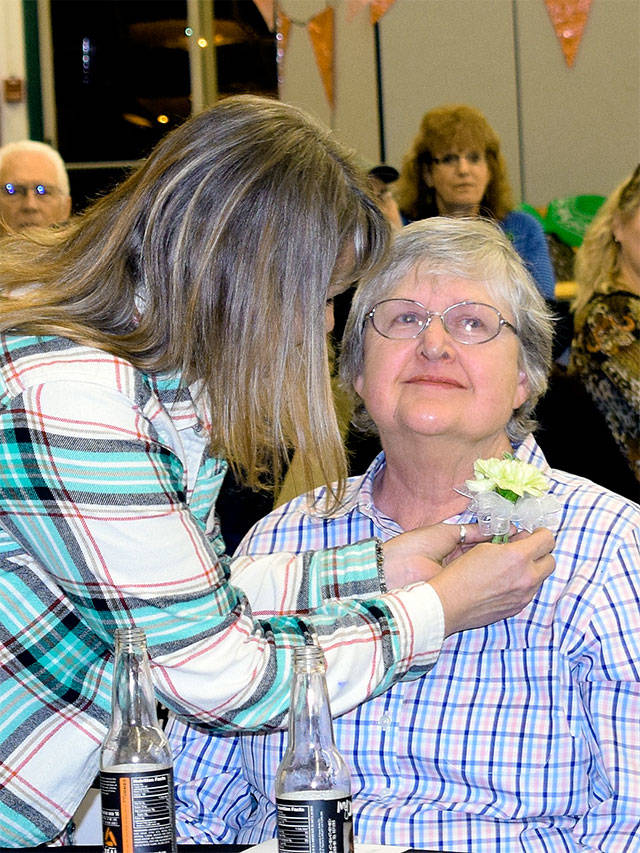 2018 Fair Honoree Elaine Wilson gets pinned with a corsage by Evergreen State Fair Superintendent Coordinator Sherry Stovner during the annual Fair Kickoff dinner on March 13. (Contributed photo)
