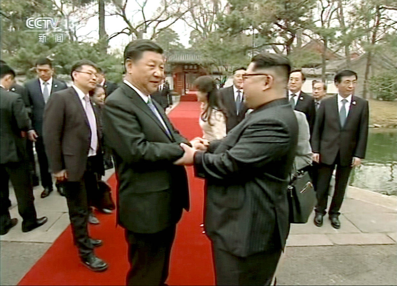 North Korean leader Kim Jong Un (right) and Chinese counterpart Xi Jinping shake hands at Diaoyutai State Guesthouse in Beijing. (CCTV via AP Video)