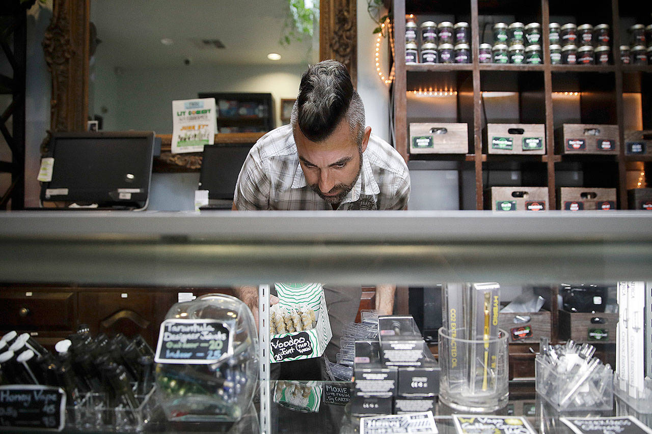 Jerred Kiloh, owner of the Higher Path medical marijuana dispensary, stocks shelves with with cannabis products in Los Angeles in June. (AP Photo/Jae C. Hong)