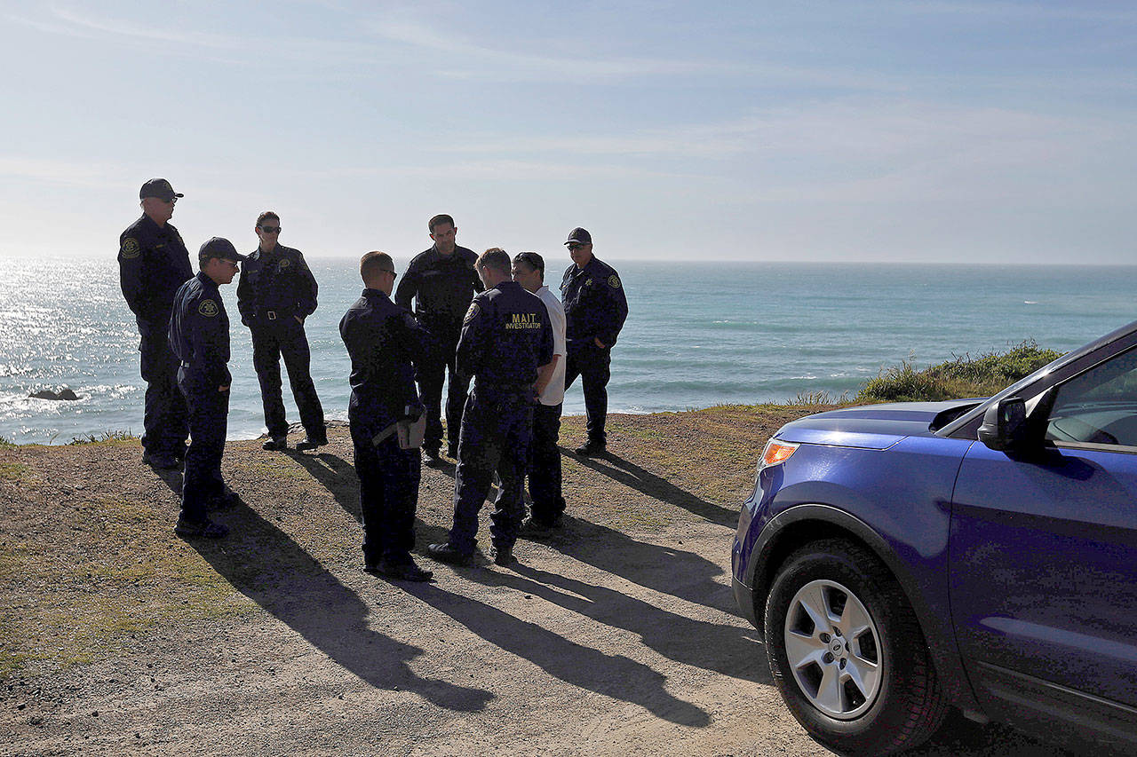 California Highway Patrol officers and deputy sheriffs from Mendocino and Alameda counties gather after a search on Wednesday at the site where a family’s SUV plunged over a cliff at a pullout on the Pacific Coast Highway near Westport, California. (Alvin Jornada/The Press Democrat via AP)