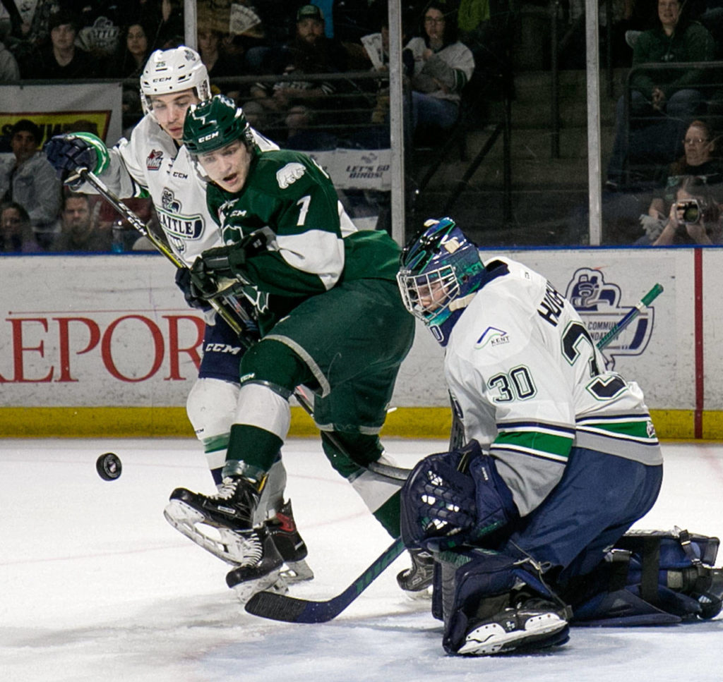 Everett’s Martin Fasko-Rudas jumps to clear the crease with Seattle’s Owen Williams (left) and Liam Hughes on Friday at ShoWare Center in Kent. (Kevin Clark / The Herald)
