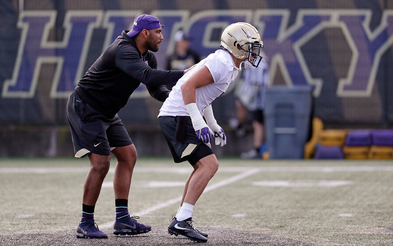 Washington assistant defensive backs coach Will Harris (left) directs Byron Murphy during a drill at the first practice of spring football on March 28, 2018, in Seattle. (AP Photo/Elaine Thompson)
