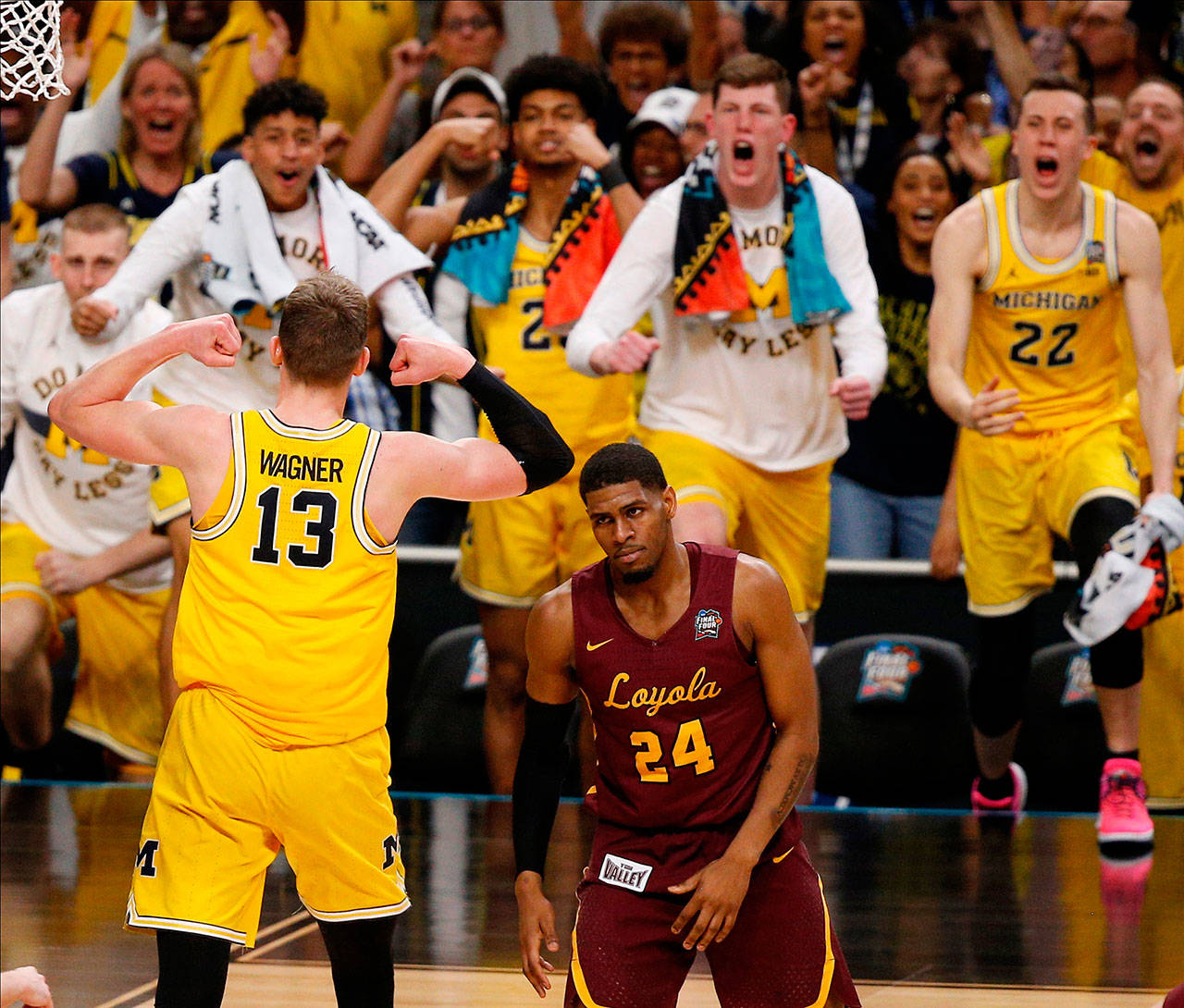 Michigan’s Moritz Wagner (13) celebrates with his teammates as Loyola-Chicago’s Aundre Jackson (24) walks off during the second half of a Final Four game on March 31, 2018, in San Antonio. (AP Photo/Brynn Anderson)