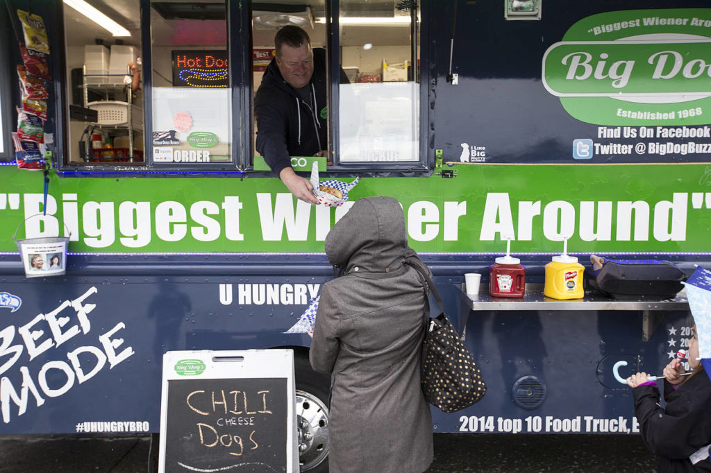 Big Dog’s owner Jerry Dixon serves up a dog at an event at Paine Field. (Ian Terry / The Herald)
