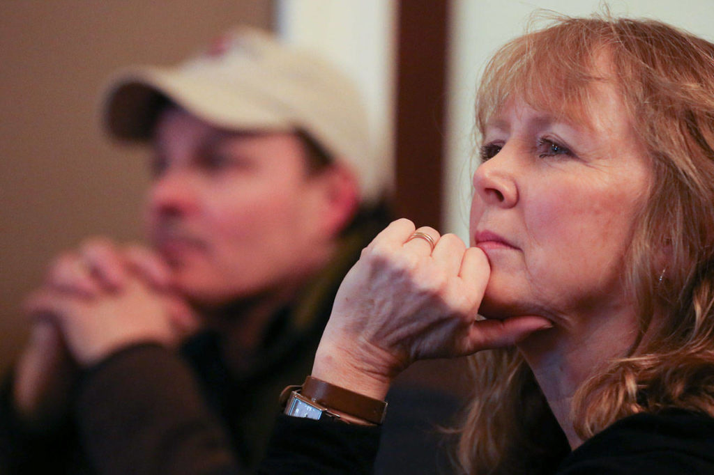 Mike Johnson and Lisa Bender listen during a meeting of Snohomish Building Bridges at Looking Glass Coffee on Feb. 1. (Kevin Clark / The Herald)
