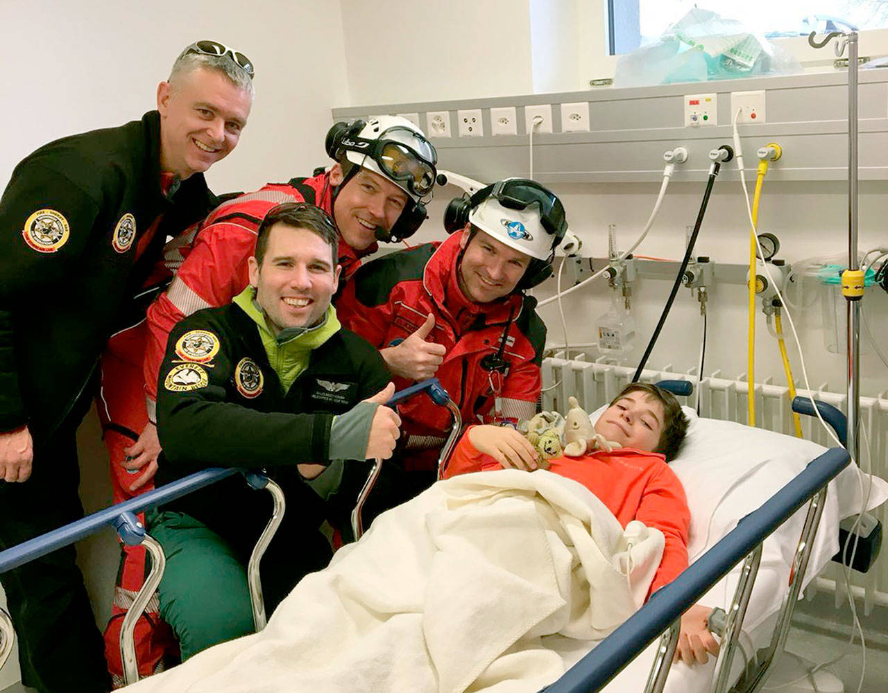 Richard Duncan (left) and Miles Mcdonough (second from left) of the Snohomish County Sheriff’s Office helicopter rescue team pose with Swiss helicopter crew members Peter Lackermeier (third from left) and Oliver Kreuzer with the boy they helped rescue after a skiing accident on Rothorn mountain in Switzerland.