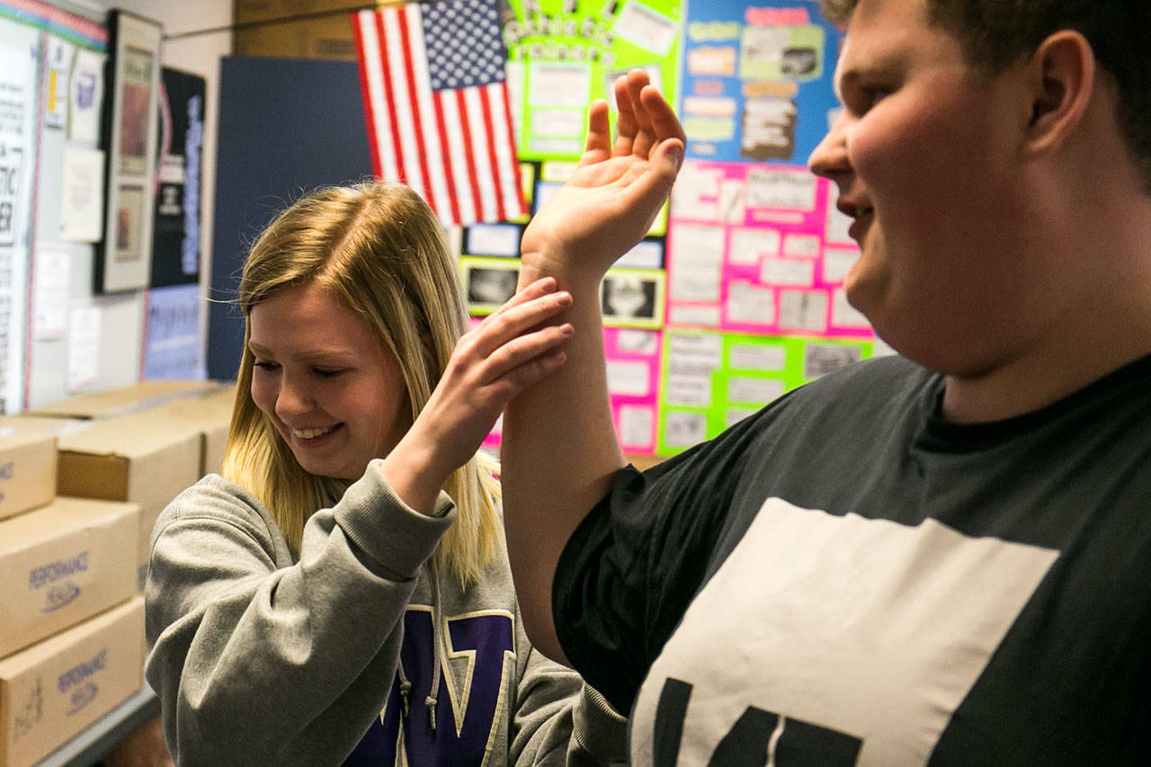 Britney Chatterton examines Landon Olson on Monday afternoon during Heather Sevier’s advanced sports medicine class at Monroe High School. (Kevin Clark / The Herald)