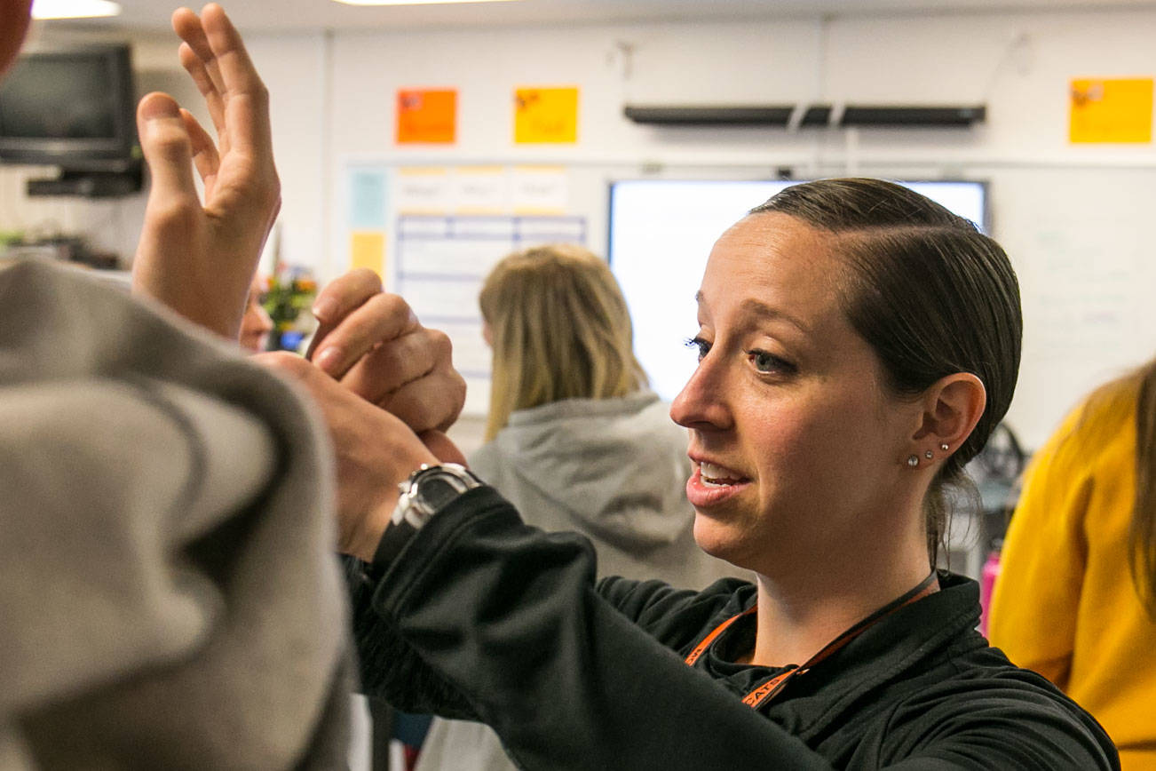 Heather Sevier shows the proper way technique in her advanced sports medicine class Monday afternoon at Monroe High School in Monroe on March 26, 2018. (Kevin Clark / The Daily Herald)