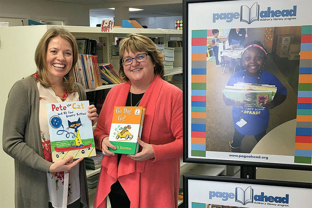 Cheri Ryan of the Elizabeth Ruth Wallace Living Trust congratulates Susan Dibble of Page Ahead with a grant that will allow the nonprofit to provide books and reading programs to Edmonds School District students. (Contributed photo)