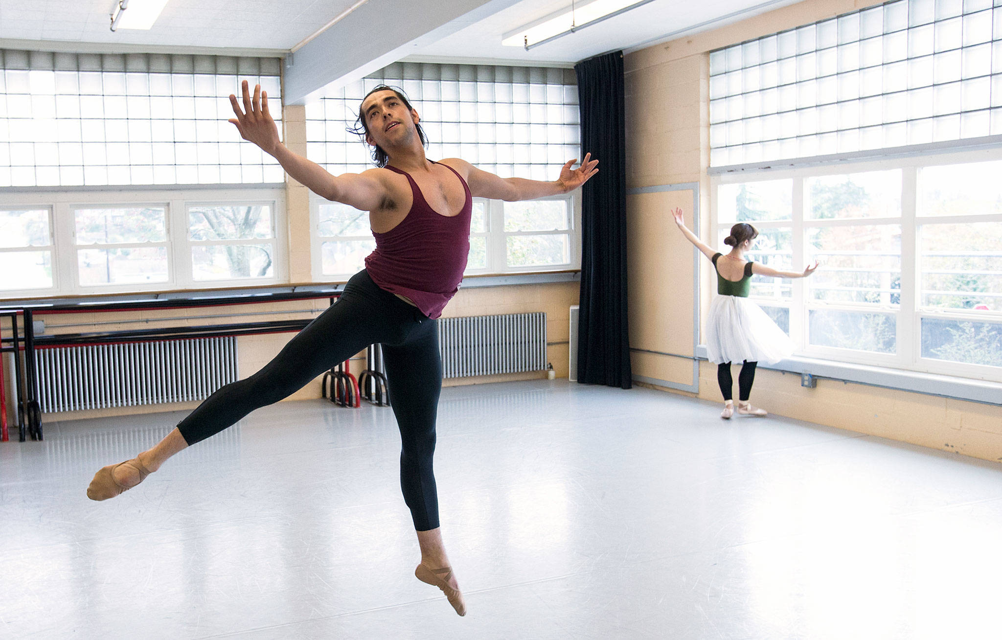 Olympic Ballet Theatre dancer Alberto Gaspar leaps as Airi Miyata goes through her steps during a rehearsal for their upcoming performance of “Copellia.” (Andy Bronson / The Herald)