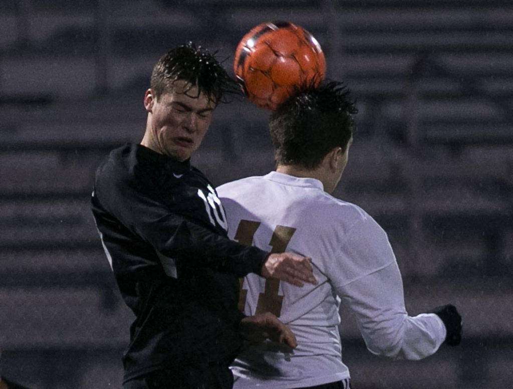 Jackson’s Jake Williams (left) and Lake Stevens’ Ethan Anastasi jump for a header Wednesday at Lake Stevens High School. (Kevin Clark / The Herald)
