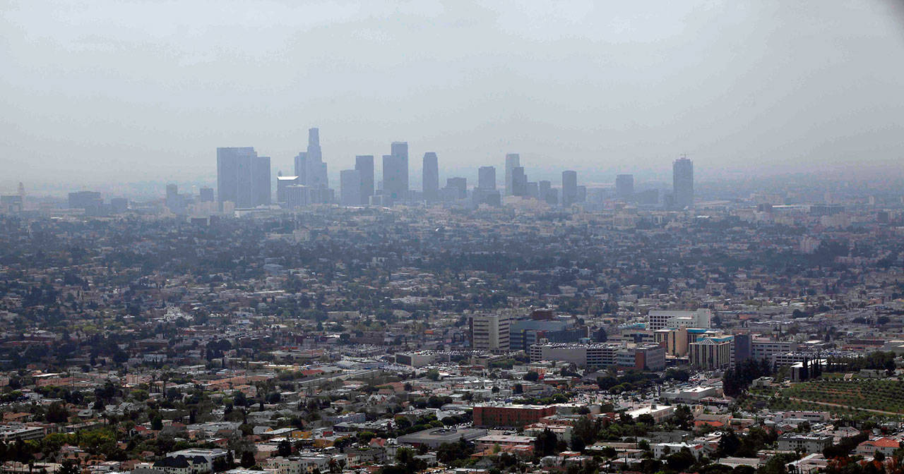 Smog covers downtown Los Angeles in April of 2009. California Attorney General Xavier Becerra and attorneys general for several other states, including Washington, say they will challenge the EPA’s decision to lower mileage and emission standards for cars and light trucks. (Nick Ut/Associated Press file photo)