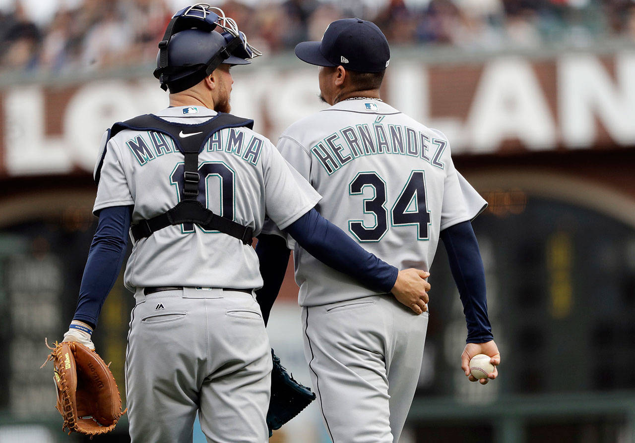 Mariners catcher Mike Marjama (left) talks to starting pitcher Felix Hernandez after Hernandez gave up a run to the Giants during the first inning on April 4, 2018, in San Francisco. (AP Photo/Marcio Jose Sanchez)