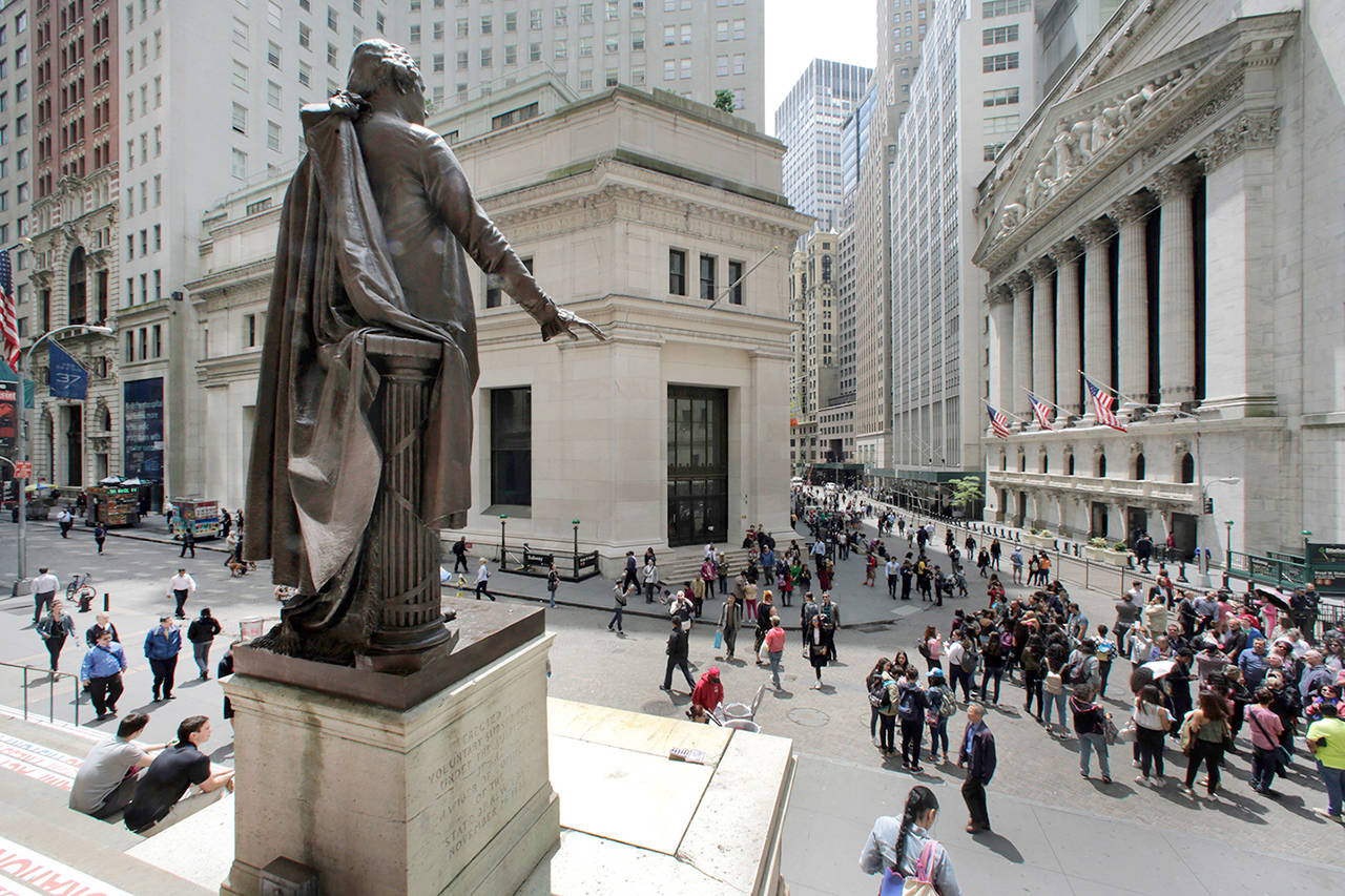 The statue of George Washington, on the steps of the Federal Hall National Monument, overlooks Wall Street and the New York Stock Exchange in May 2016 in New York’s Financial District. (AP Photo/Richard Drew, file)