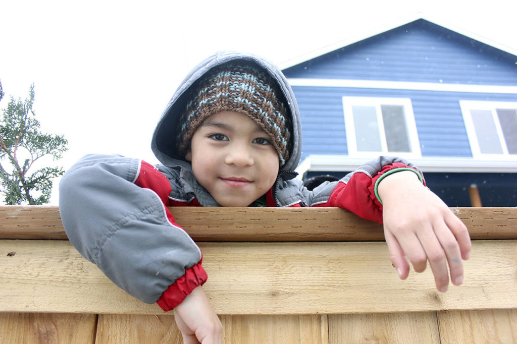 Ray Flores Jr. hangs out in front of his Habitat home in Everett. (Habitat for Humanity of Snohomish County)
