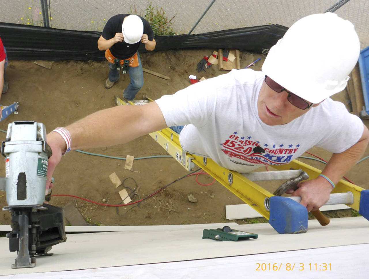 Local radio show host Stitch Mitchell works on siding at a Habitat home in Everett. (Habitat for Humanity of Snohomish County)