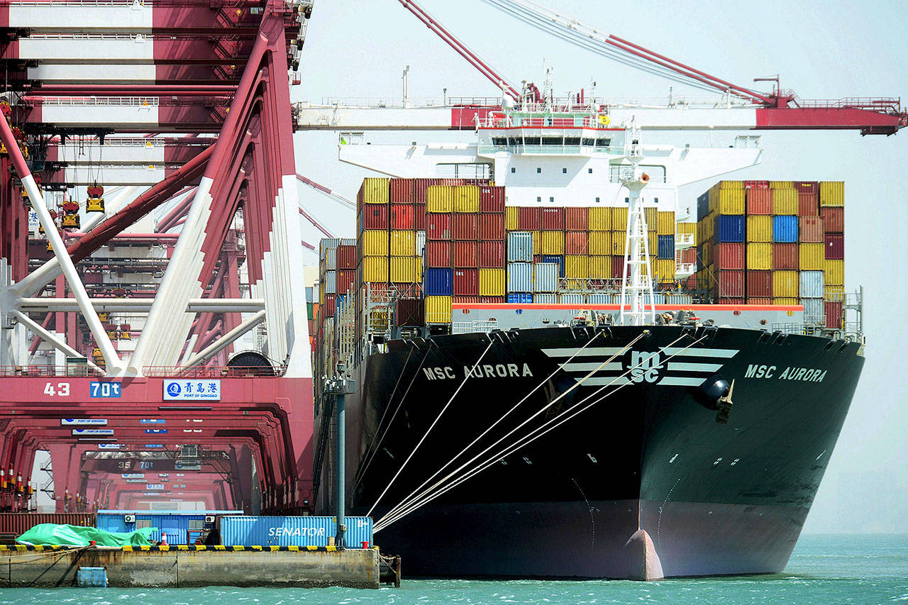 Containers are loaded onto a cargo ship at the port in Qingdao in China’s Shandong province on Friday. (Chinatopix via AP)