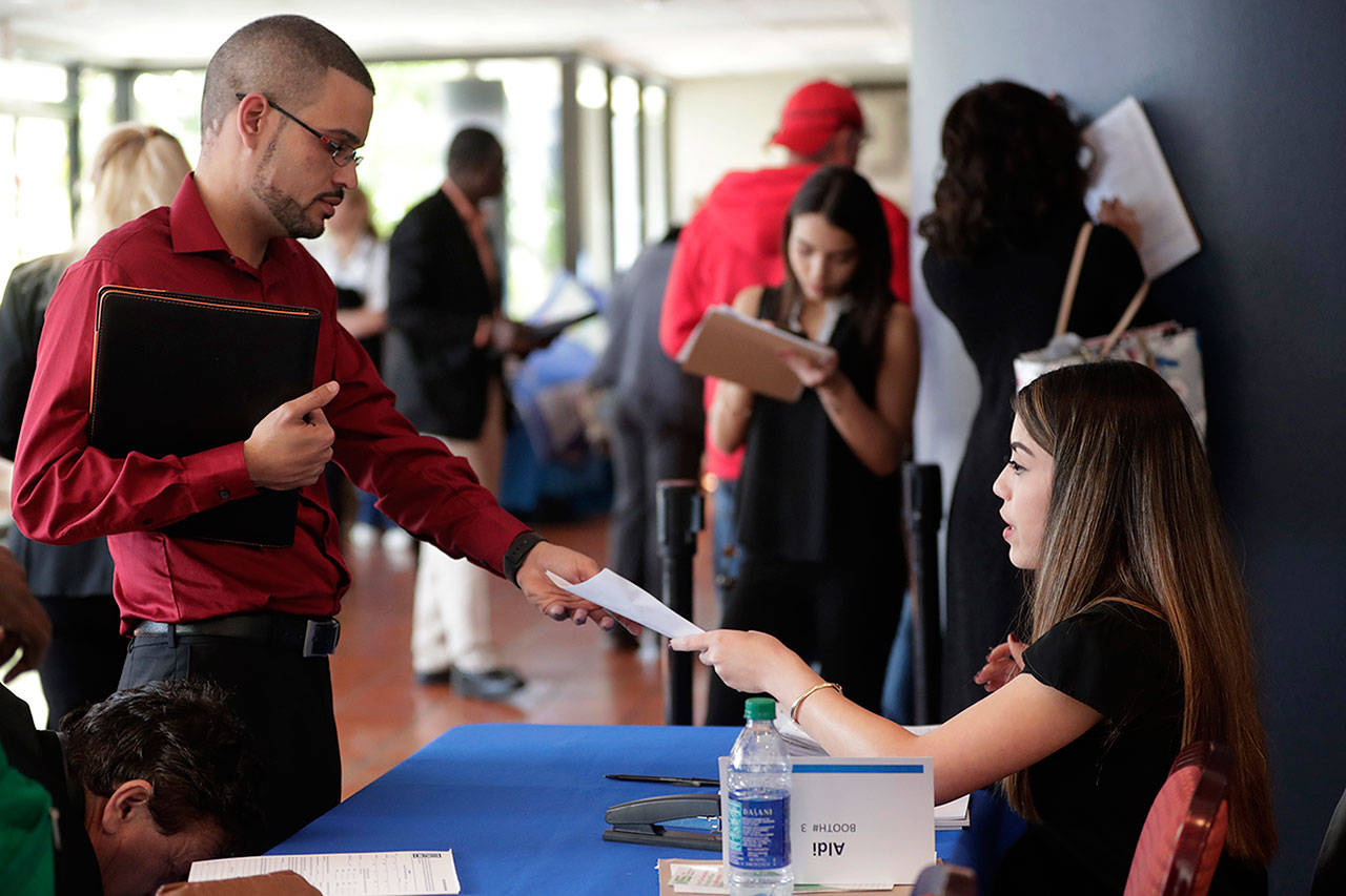 An employee of Aldi, right, takes an application from a job applicant at a JobNewsUSA job fair in Miami Lakes, Fla. (AP Photo / Lynne Sladky, File)