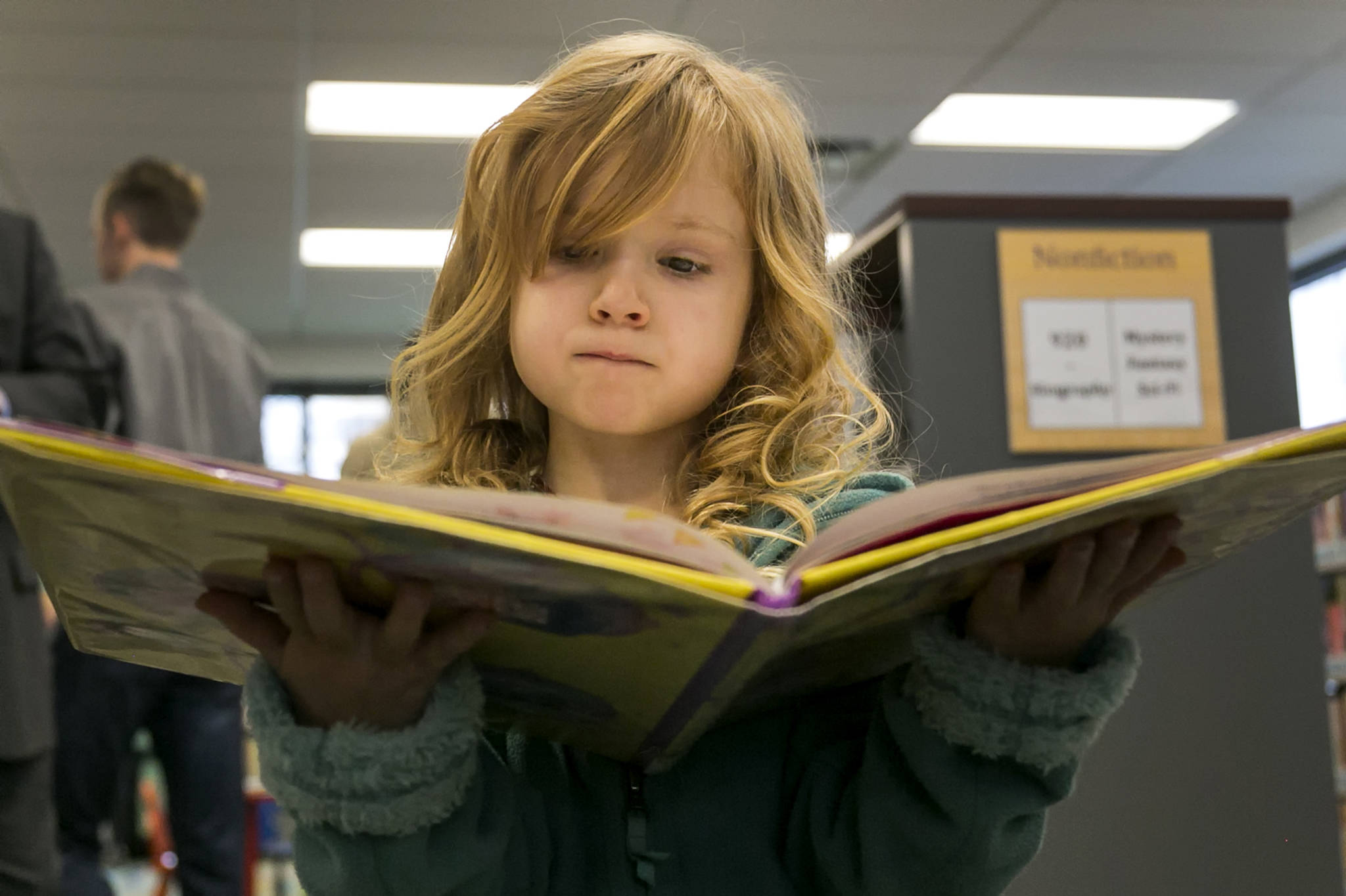 Paisley Molnick, 5, reads a book during the grand opening of the new Sno-Isle Libraries branch at Lakewood/Smokey Point in January. Sno-Isle Libraries is seeking voter approval of a levy increase in the April 24 special election. (Kevin Clark/The Daily Herald)