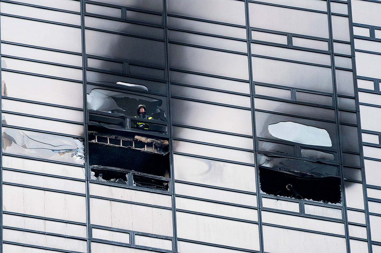 A firefighter looks out from the window of a fire damaged apartment in Trump Tower in New York on Saturday. (Craig Ruttle / AP Photo)