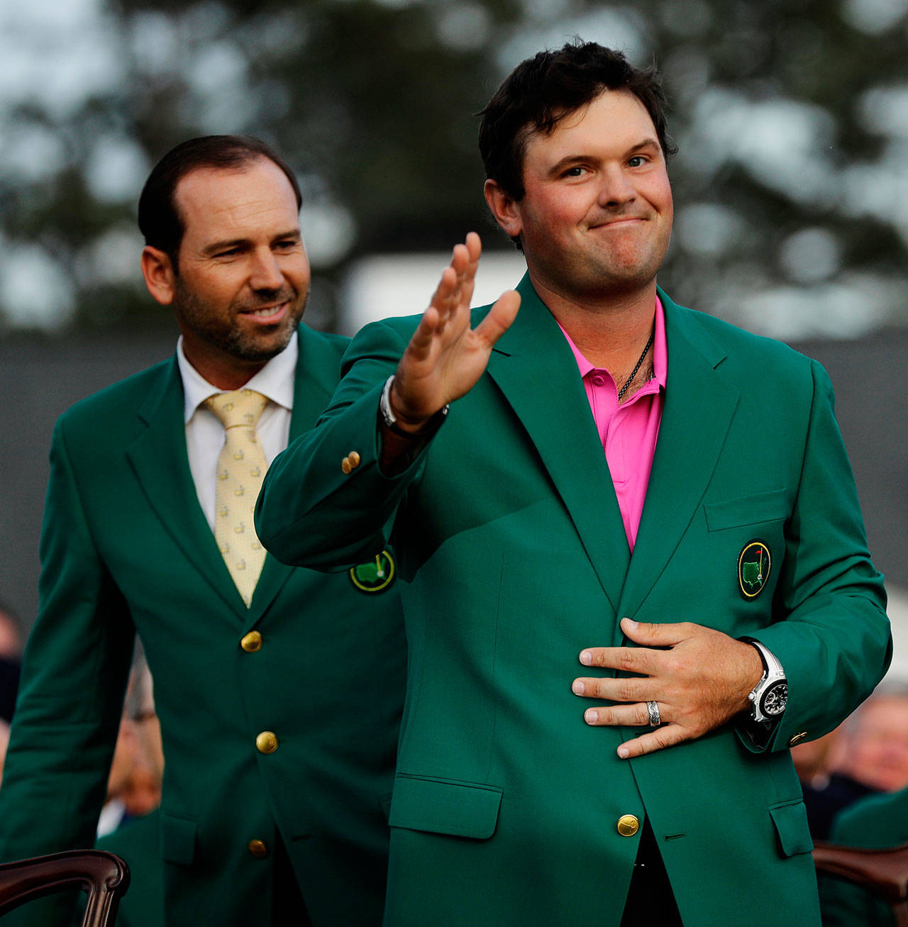 Last year’s Masters champion, Sergio Garcia (left), watches as Patrick Reed waves to spectators after Reed won the Masters on Sunday in Augusta, Ga. (AP Photo/David J. Phillip)