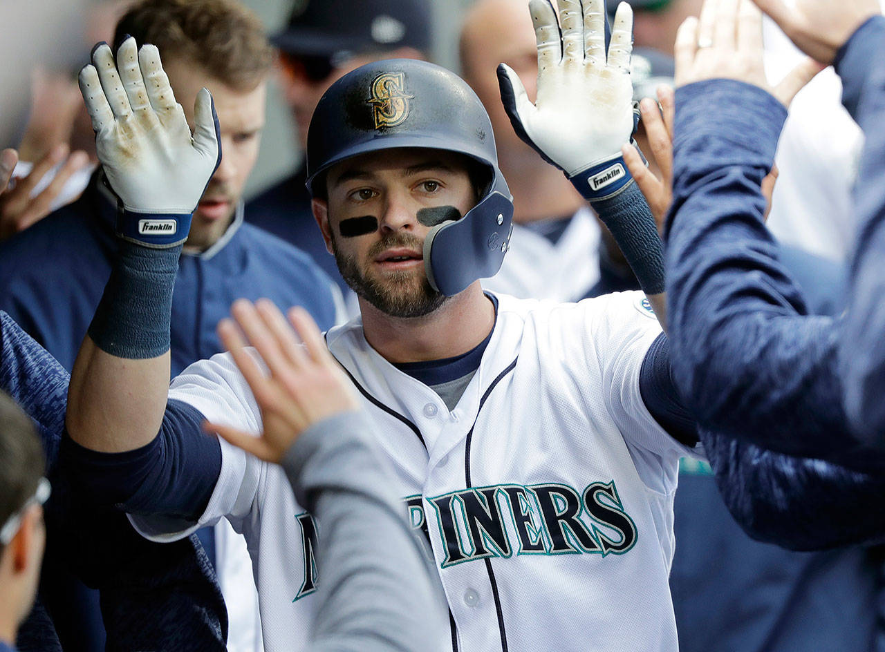 Seattle Mariners outfielder Mitch Haniger is greeted in the dugout after hitting a solo home run against the Cleveland Indians on March 31 in Seattle. (AP Photo/Ted S. Warren)