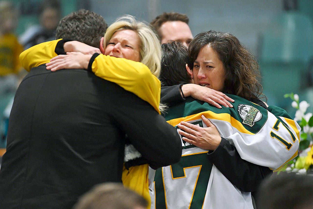 Mourners on Sunday comfort each other at a vigil at Elgar Petersen Arena, home of the Humboldt Broncos, to honor victims of Friday’s fatal bus accident in Saskatchewan. (Jonathan Hayward/The Canadian Press via AP)