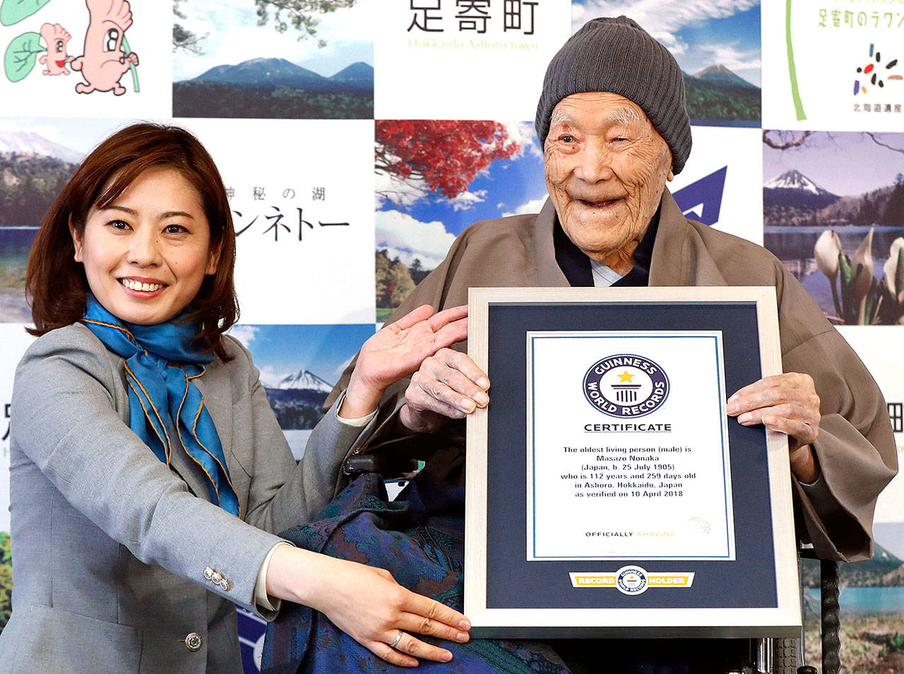 Masazou Nonaka (right) receives the certificate from Guinness World Records as the world’s oldest living man at age 112 years and 259 days during a ceremony in Ashoro on Japan’s northern main island of Hokkaido. (Masanori Takei/Kyodo News via AP)