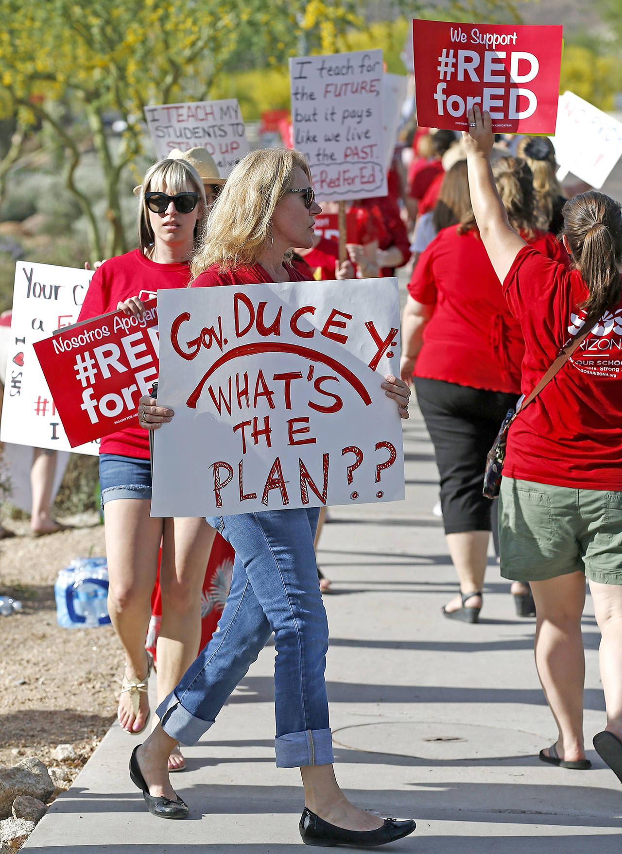 Arizona teachers march in protest of their low pay and school funding in front of a local radio station waiting for Republican Gov. Doug Ducey to show up for a live broadcast Tuesday in Phoenix. (AP Photo/Ross D. Franklin)